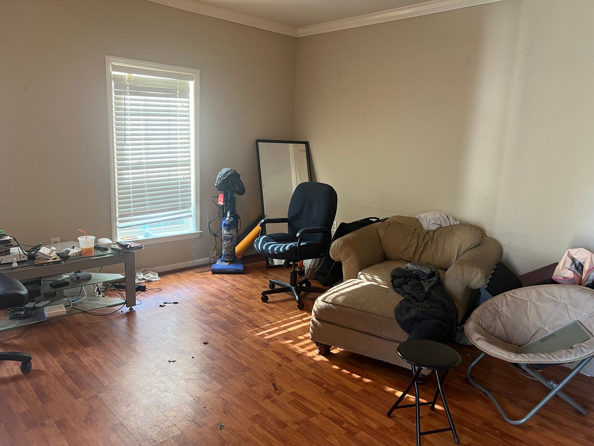 A living room with a couch , chair , table and mirror.