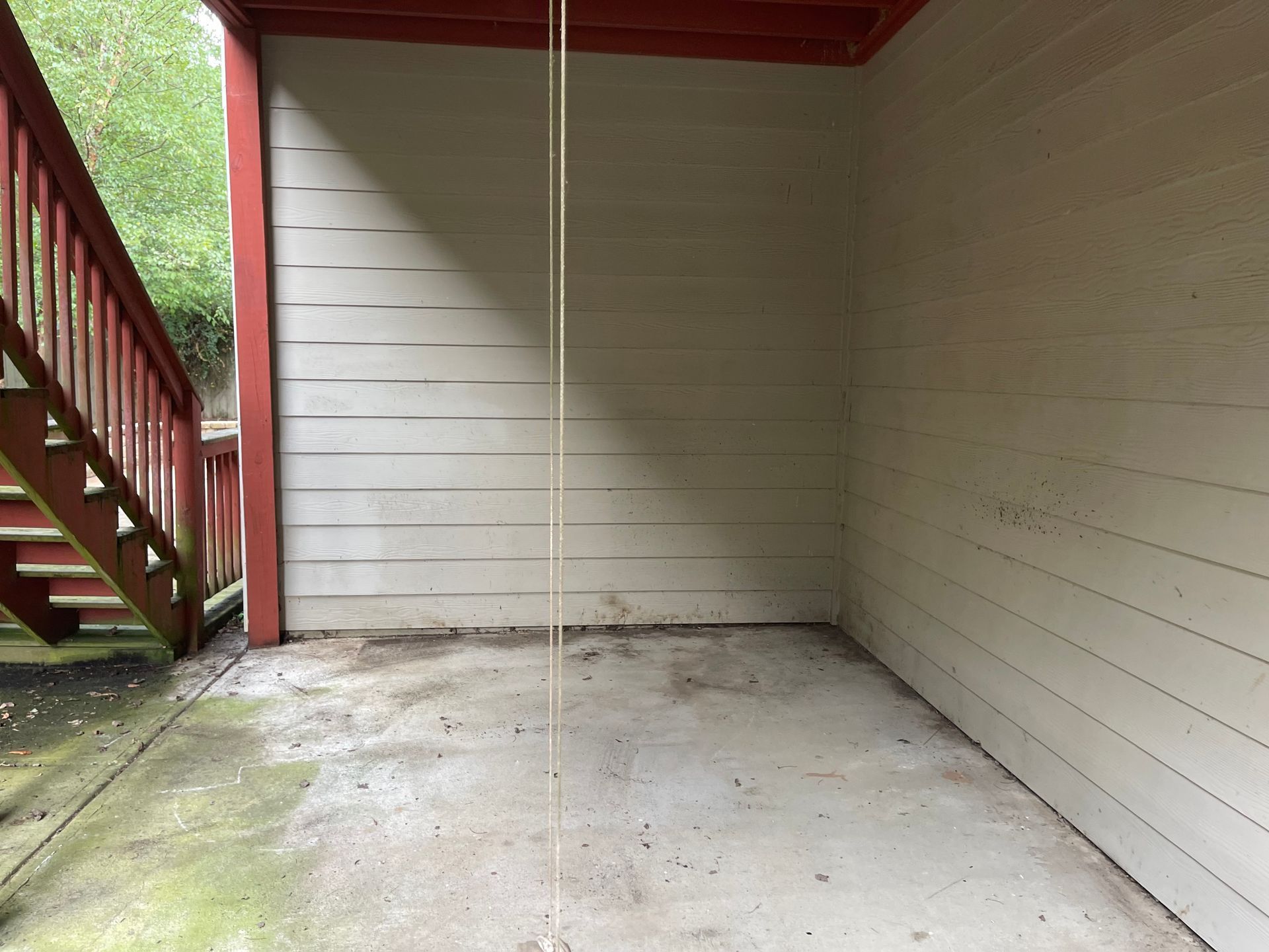 An empty room with a rope swing hanging from the ceiling
