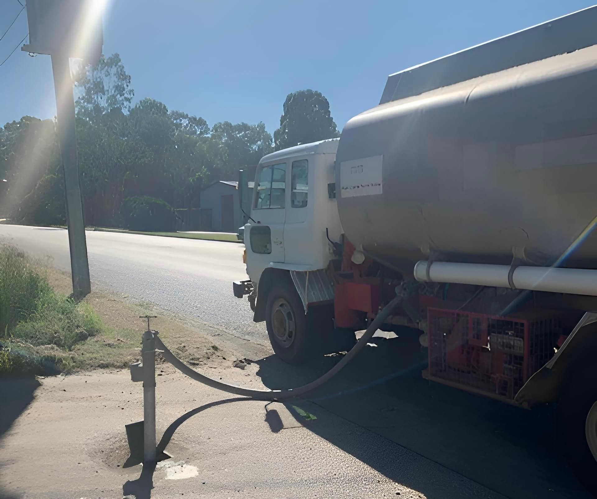 A white truck with a hose attached to it is parked on the side of the road — BB & F Constructions Pty Ltd In Taree, NSW