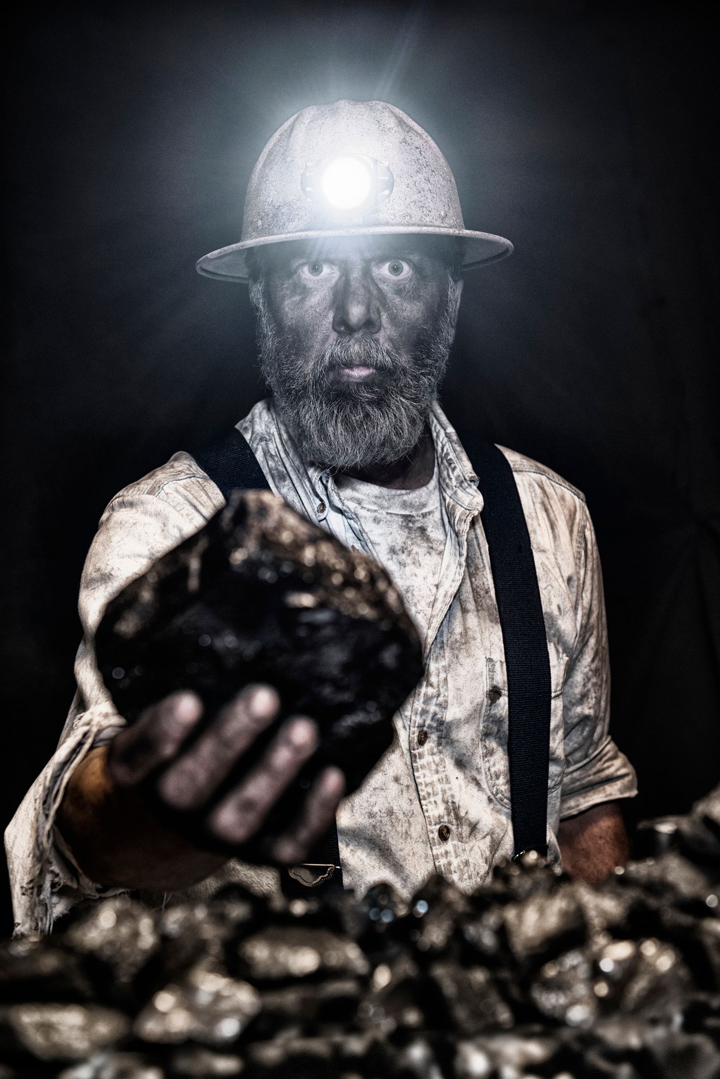 Middle-aged Caucasian coal miner, dusty, holding large coal | Morgantown, WV