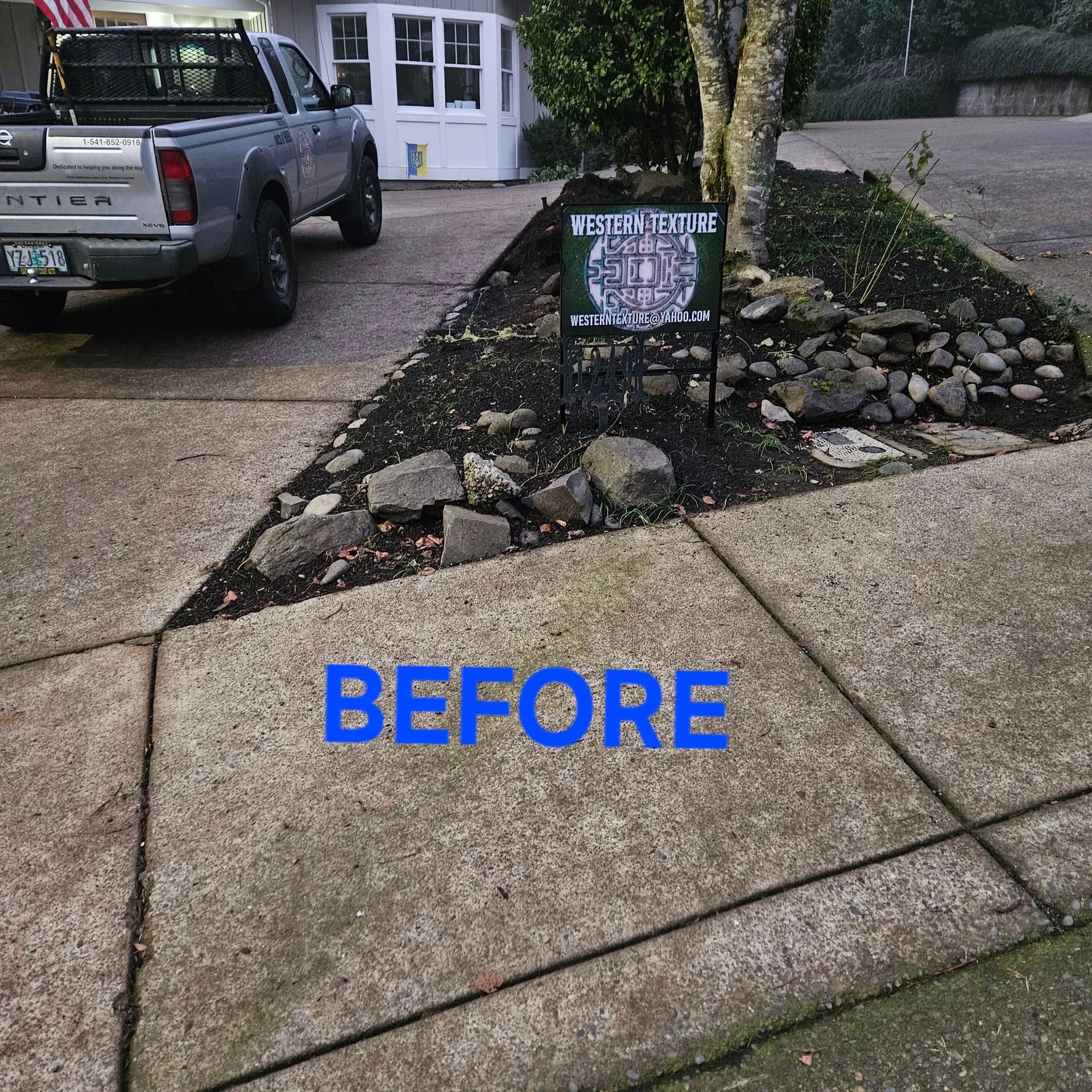 Driveway and front yard with a small rock garden and sign, labeled “BEFORE.”