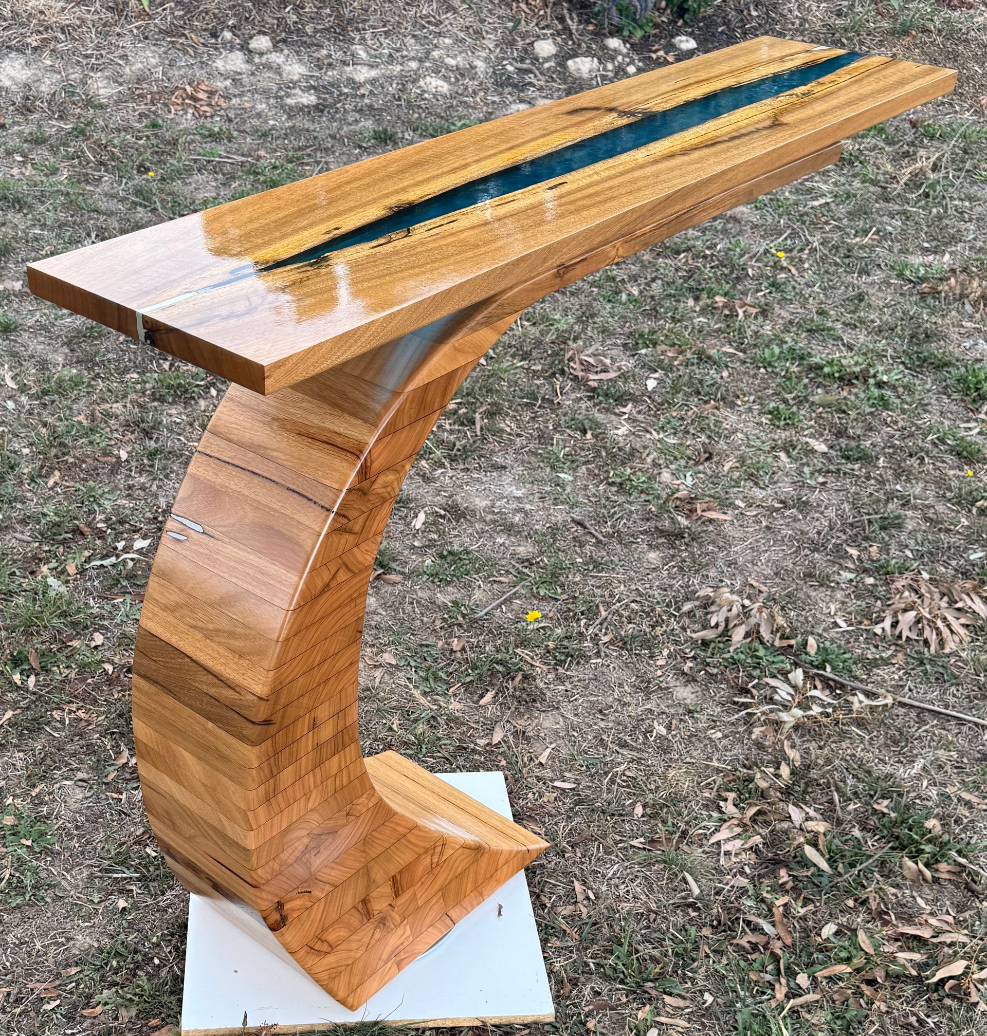 Wooden console table with curved leg, resin river down center.
