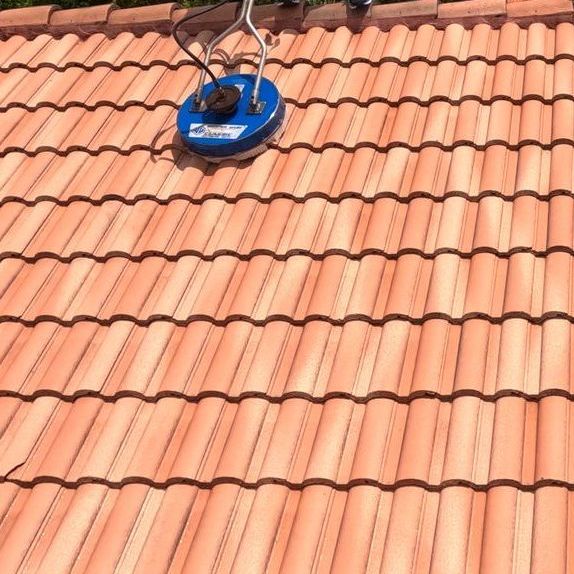 A tiled roof with a blue cleaner on top of it