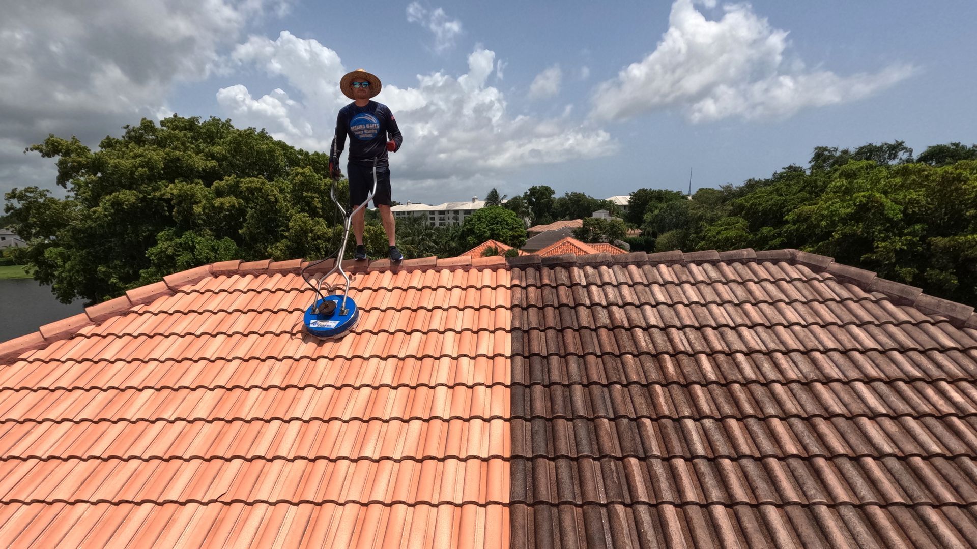 A man is standing on top of a tiled roof.