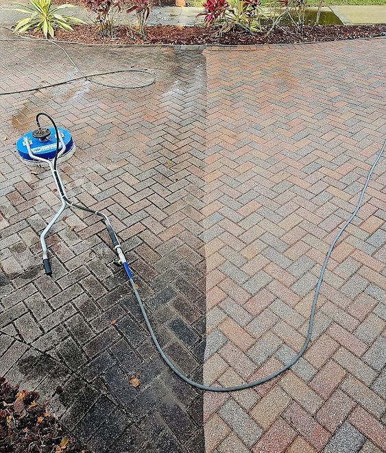 A before and after picture of a brick driveway being cleaned with a pressure washer.