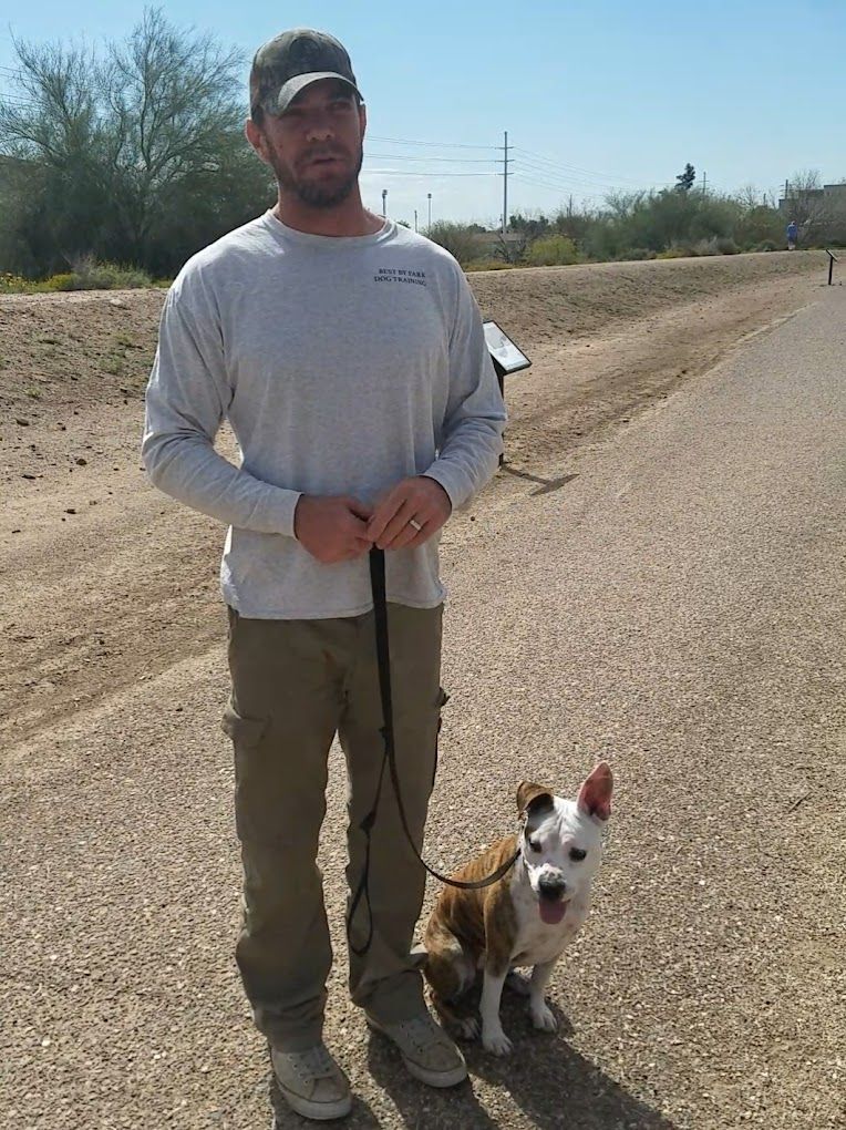 Chris Farr walking a dog on a leash on a dirt road
