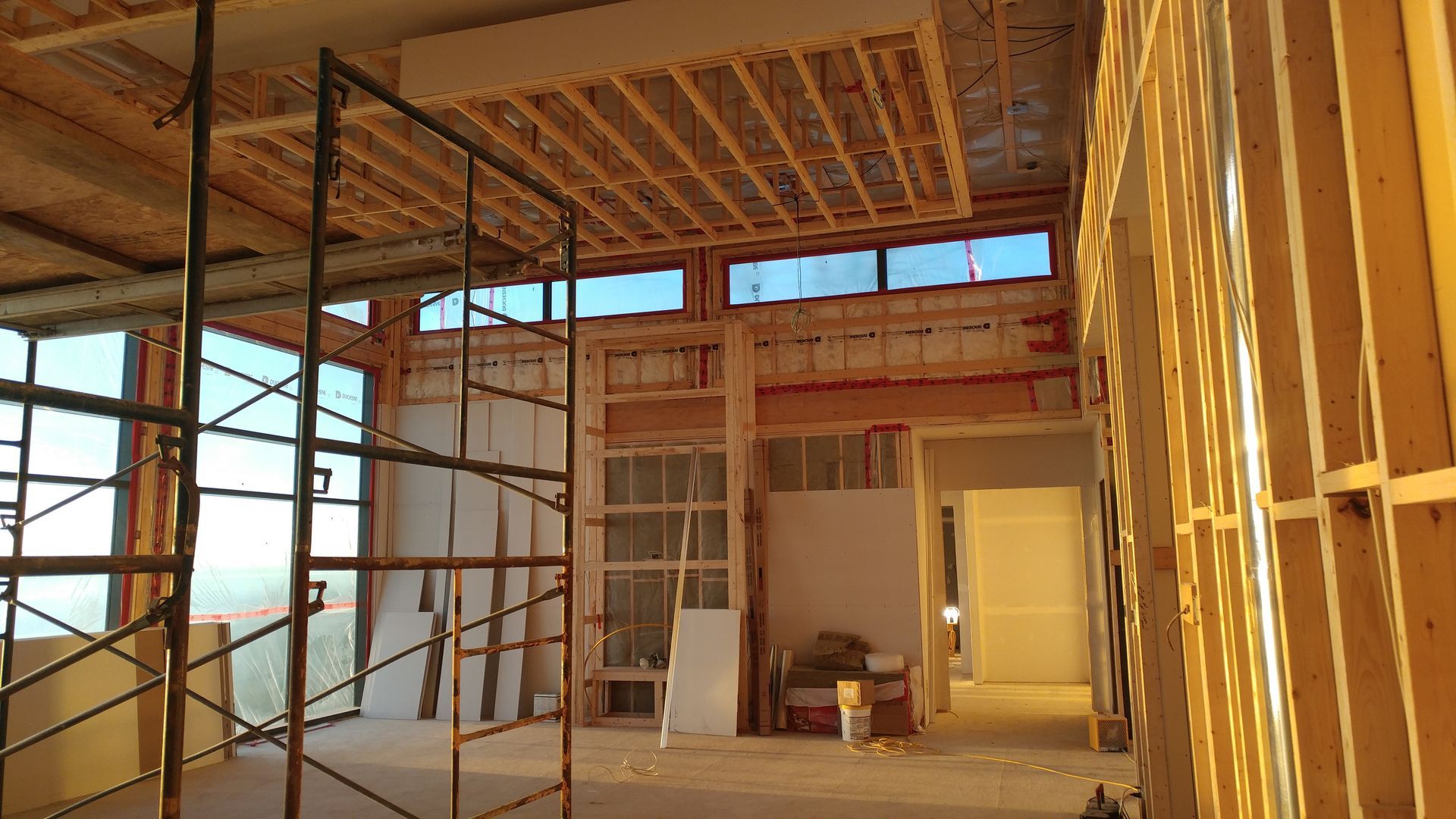 L'intérieur d'un bâtiment en construction avec échafaudages et fenêtres.