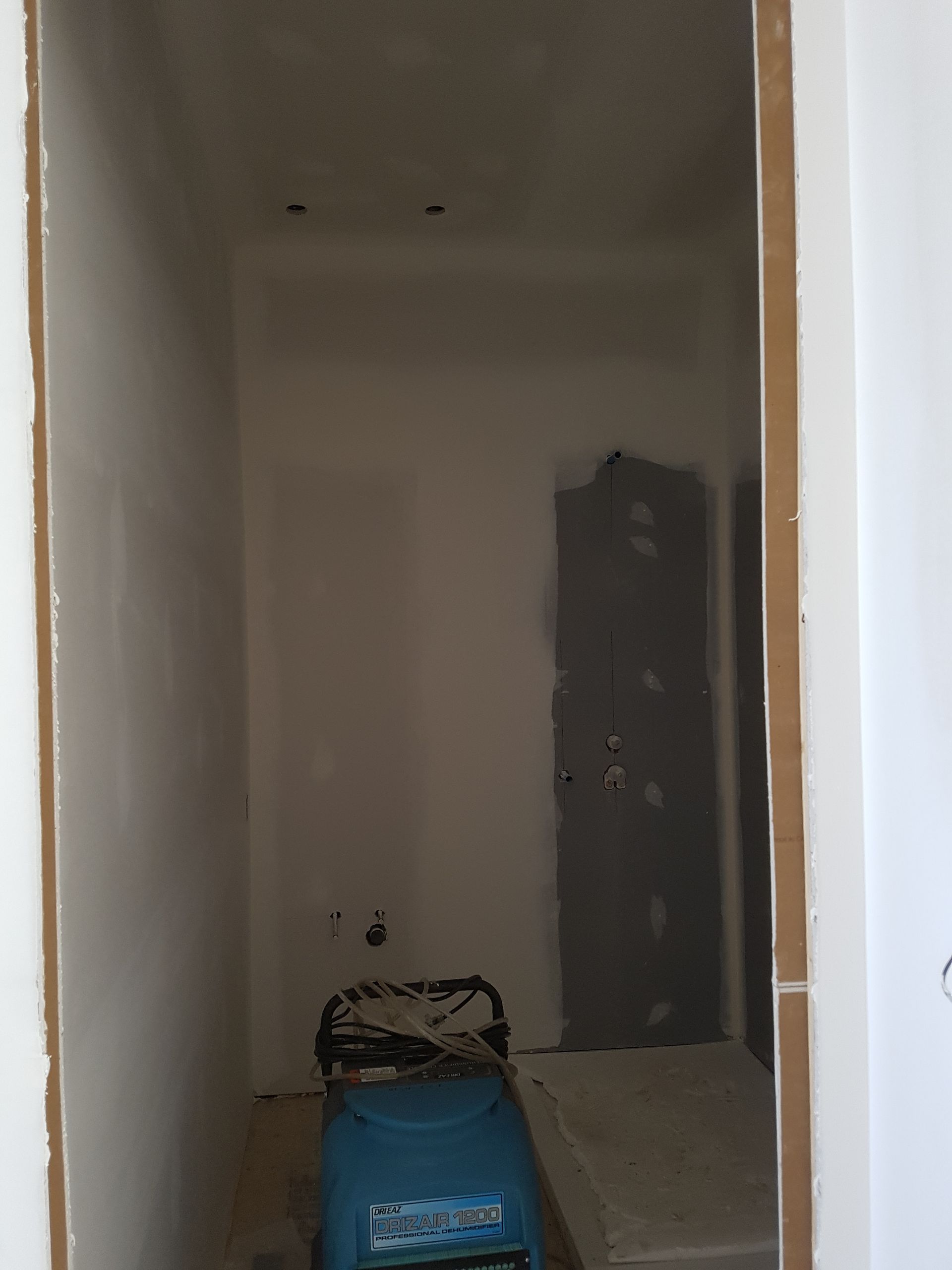 Une pièce avec une porte et un aspirateur dedans.