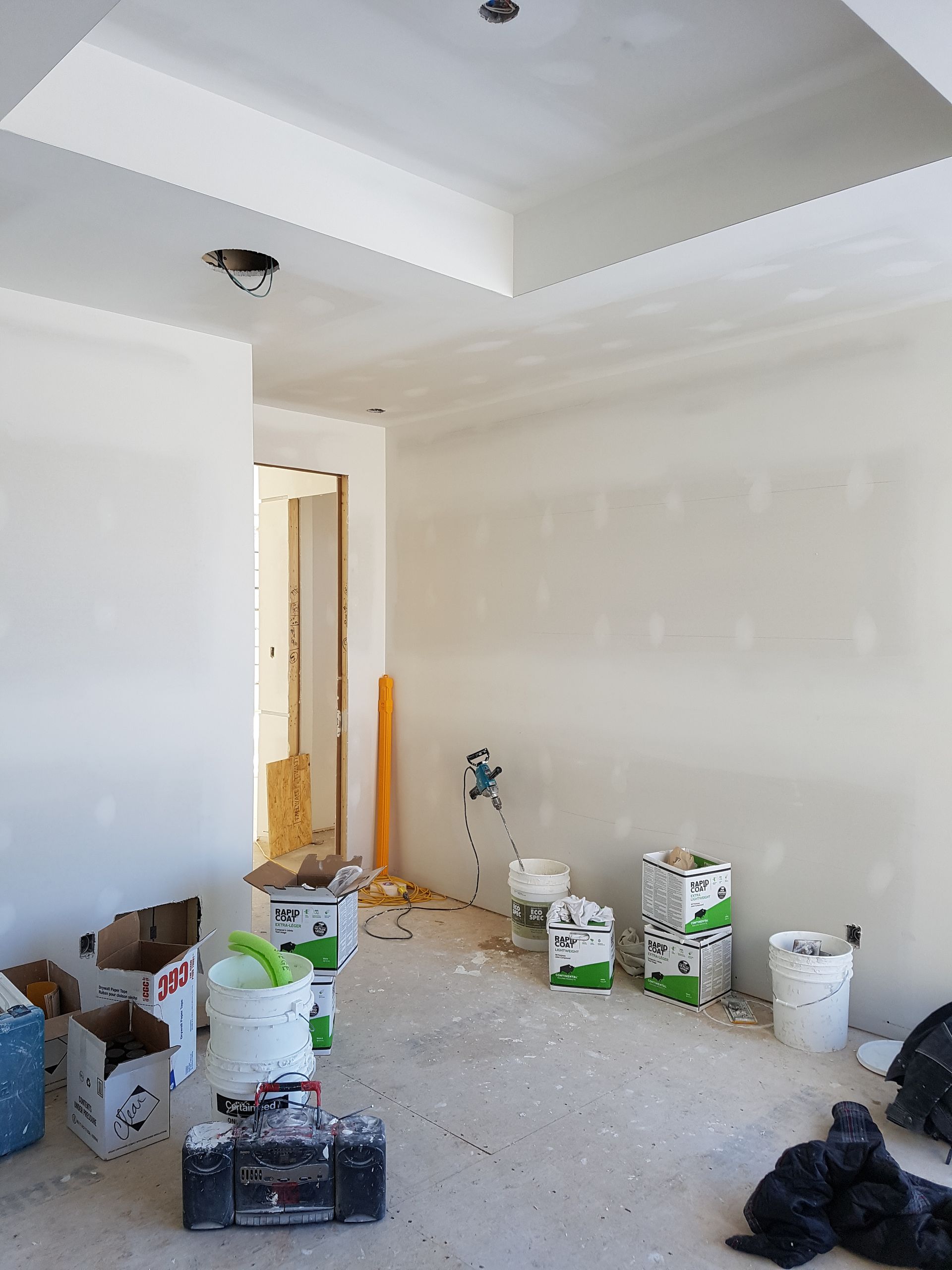 Une pièce avec beaucoup de boîtes et de seaux sur le sol