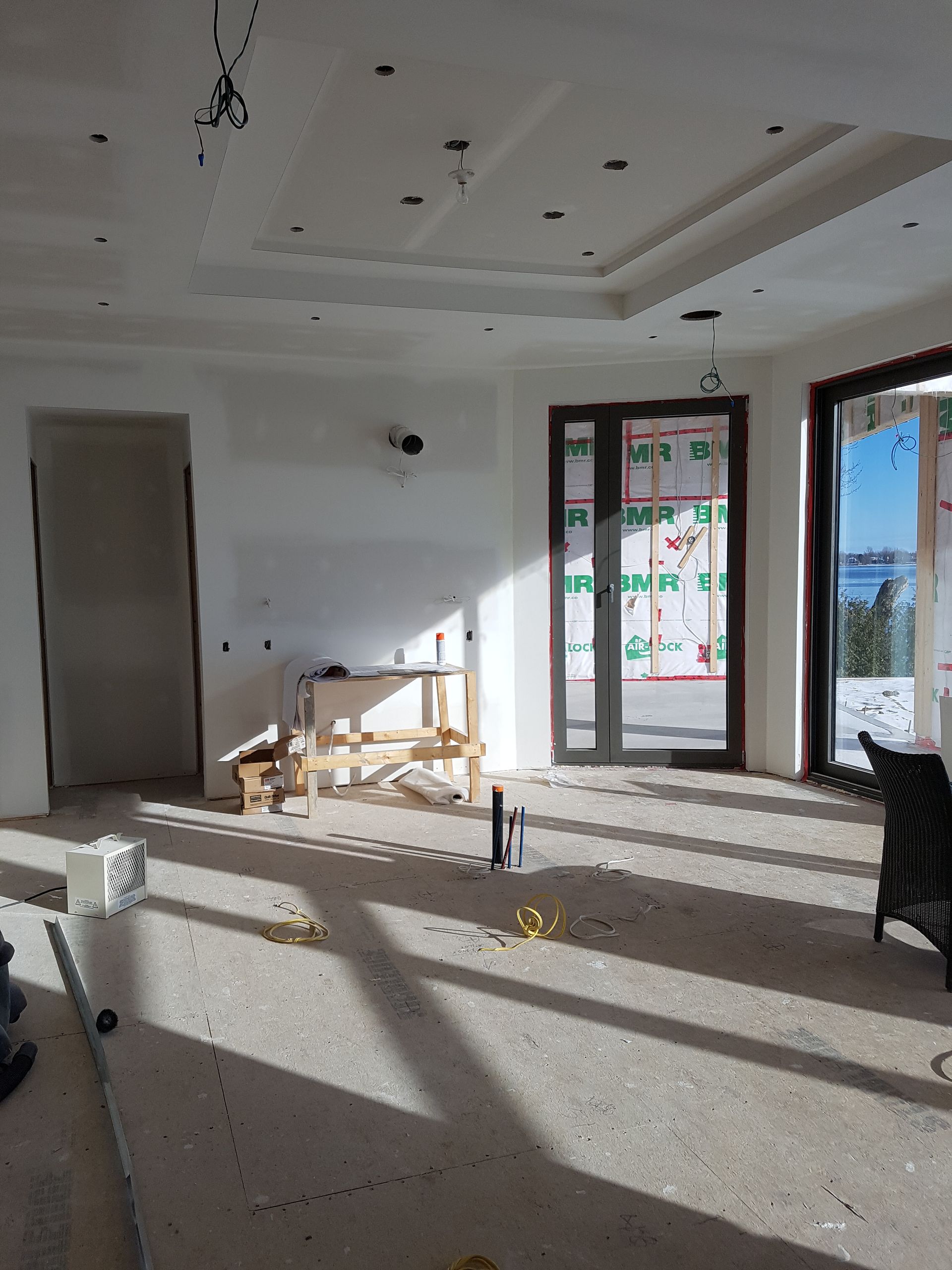 Une pièce avec beaucoup de fenêtres et une porte coulissante en verre