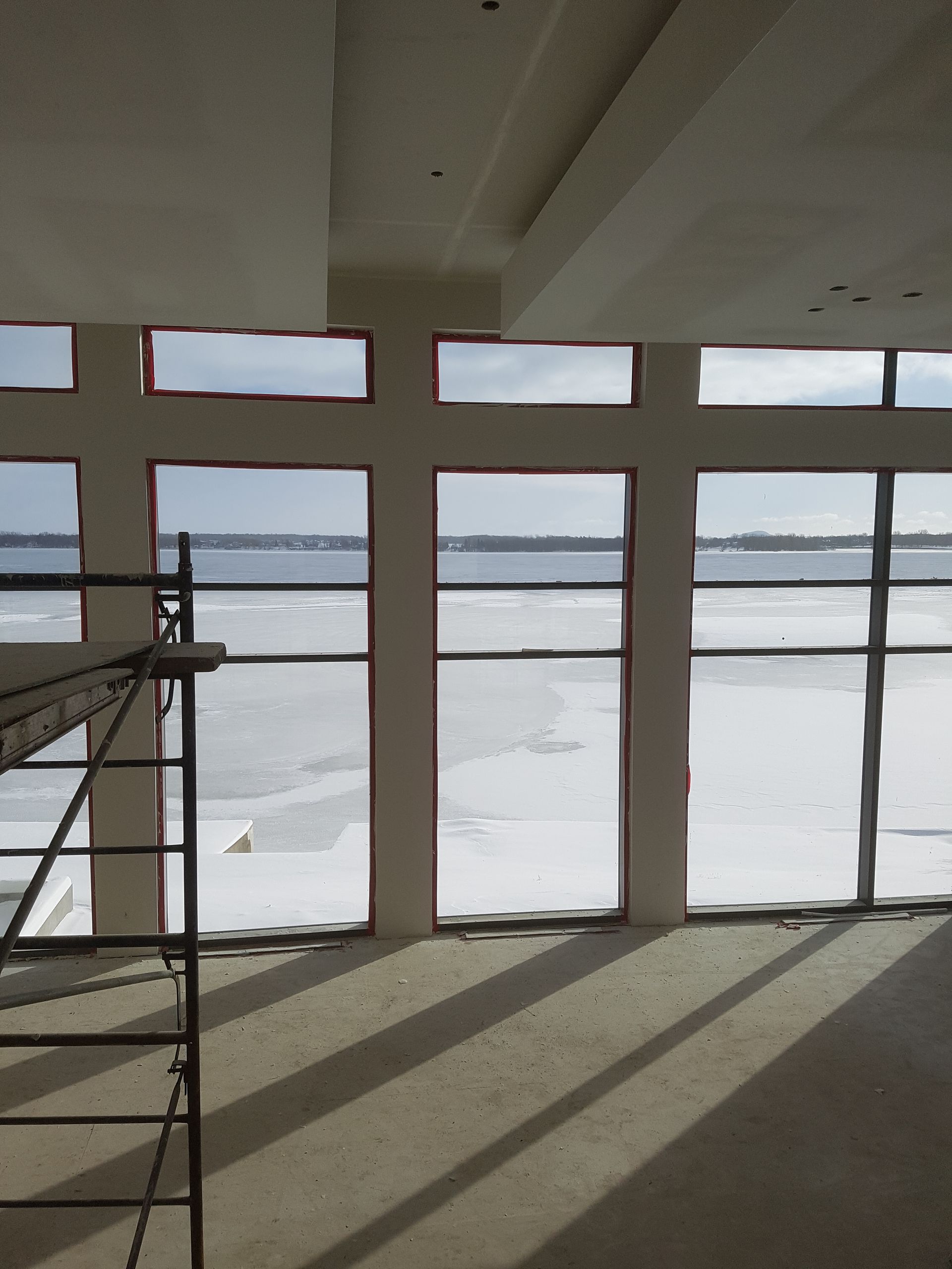 Une pièce avec beaucoup de fenêtres et de la neige dehors