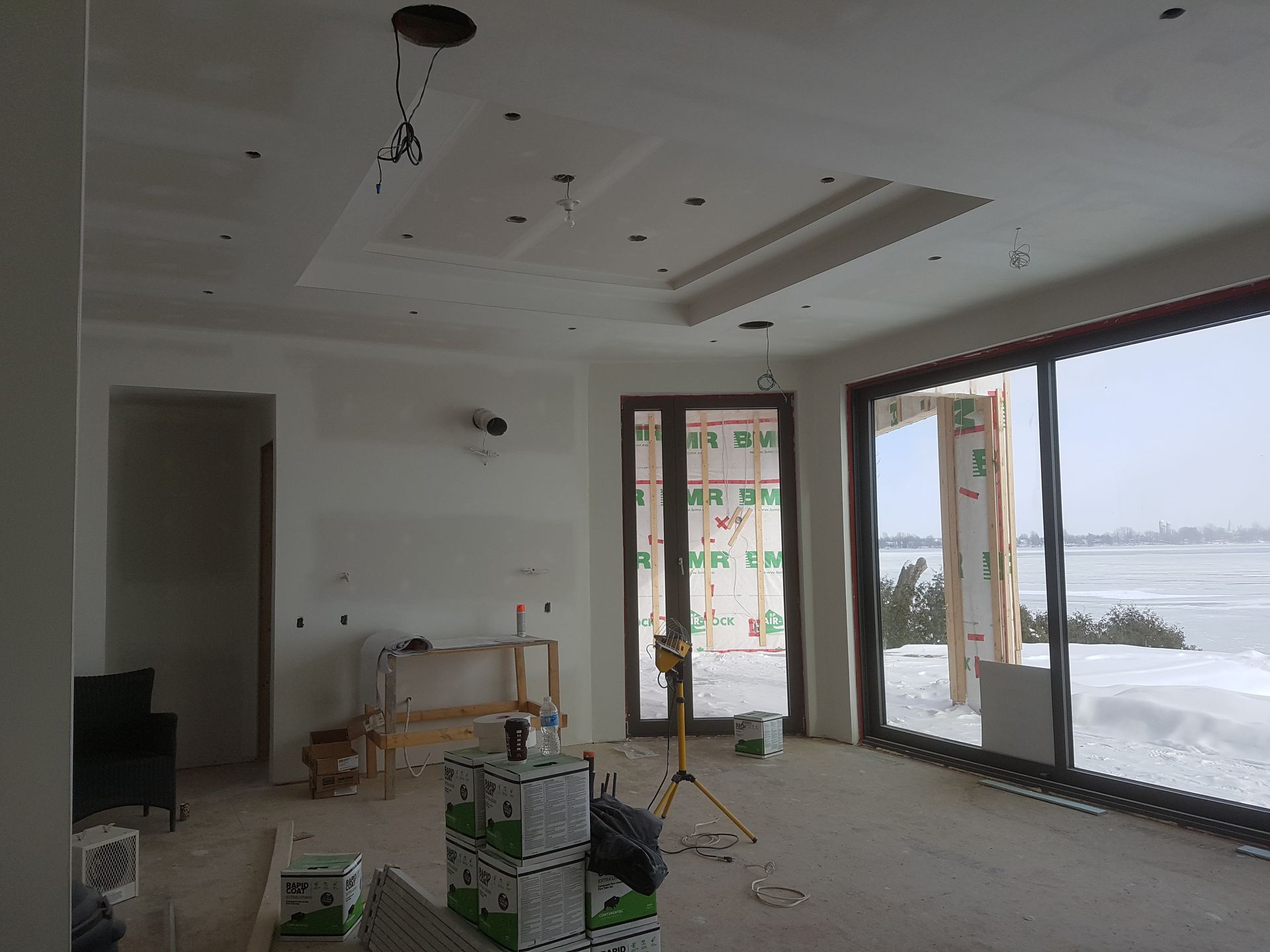 Une grande pièce avec beaucoup de fenêtres et de boîtes au sol