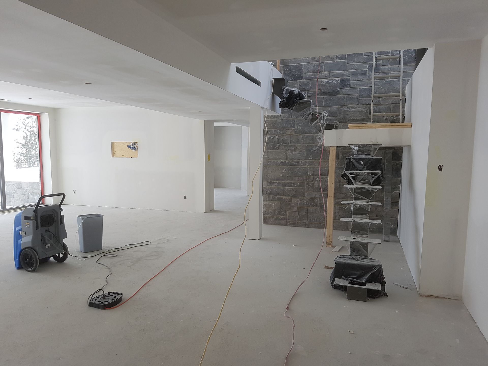 Une pièce vide avec un escalier et un aspirateur dedans.