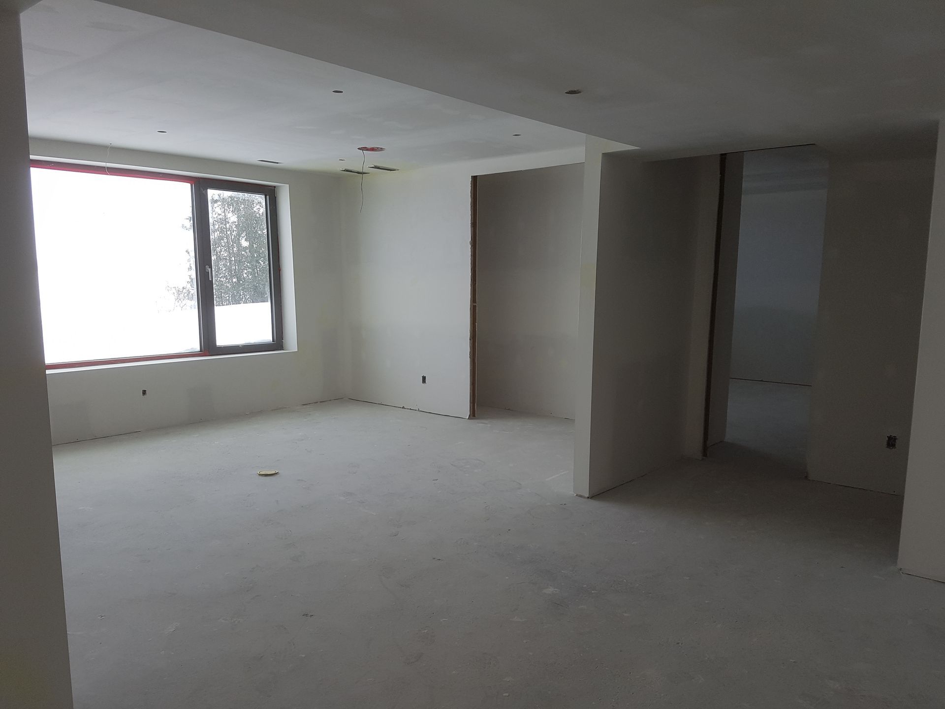 Une grande pièce vide avec une fenêtre au milieu.