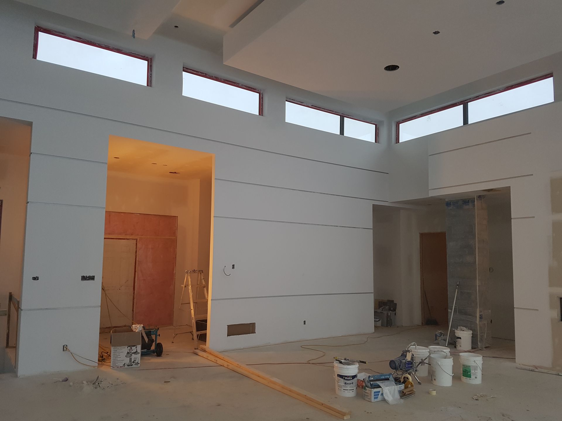 Une pièce vide avec des seaux de peinture sur le sol