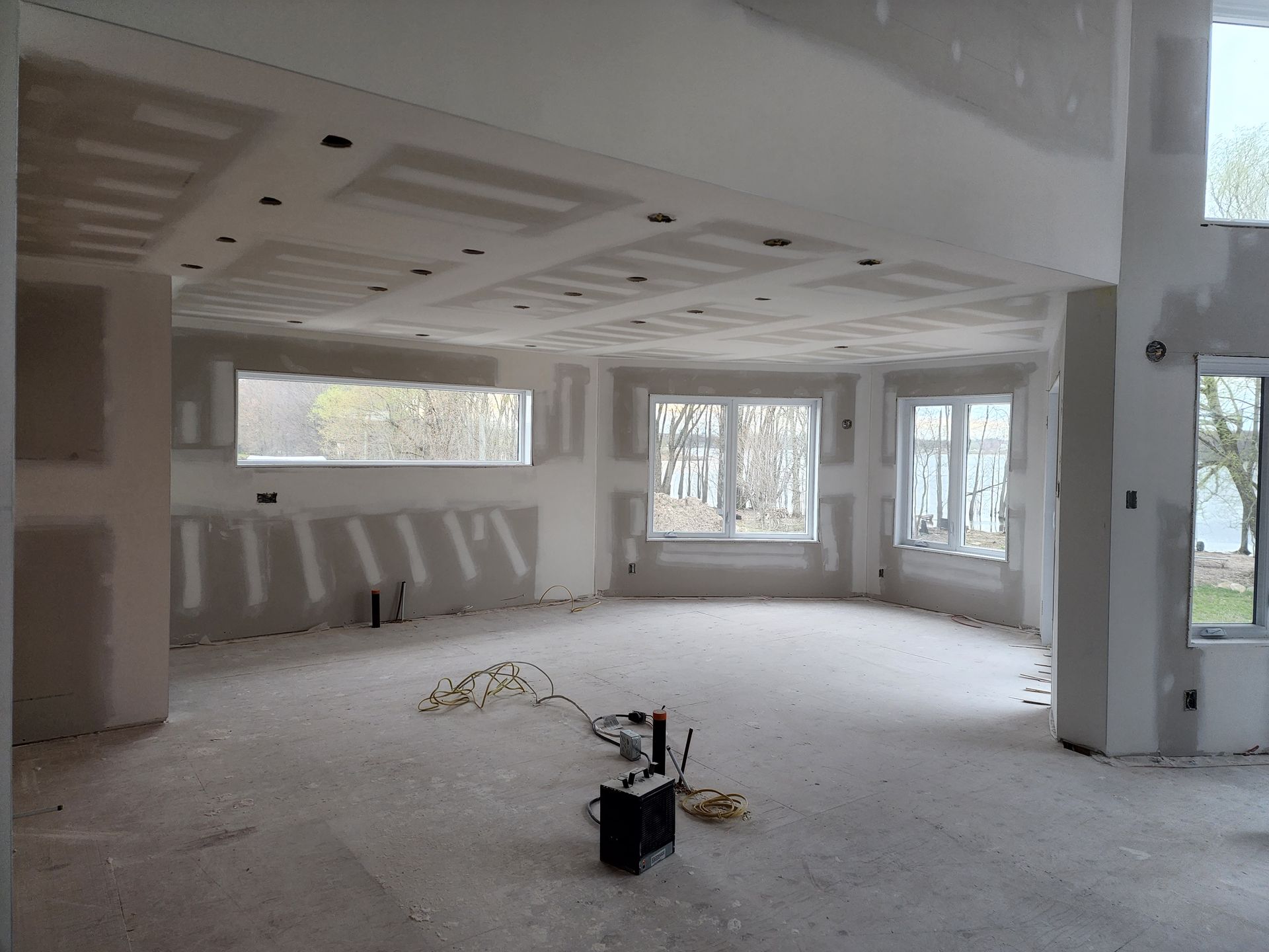Une grande pièce avec beaucoup de fenêtres et de cloisons sèches