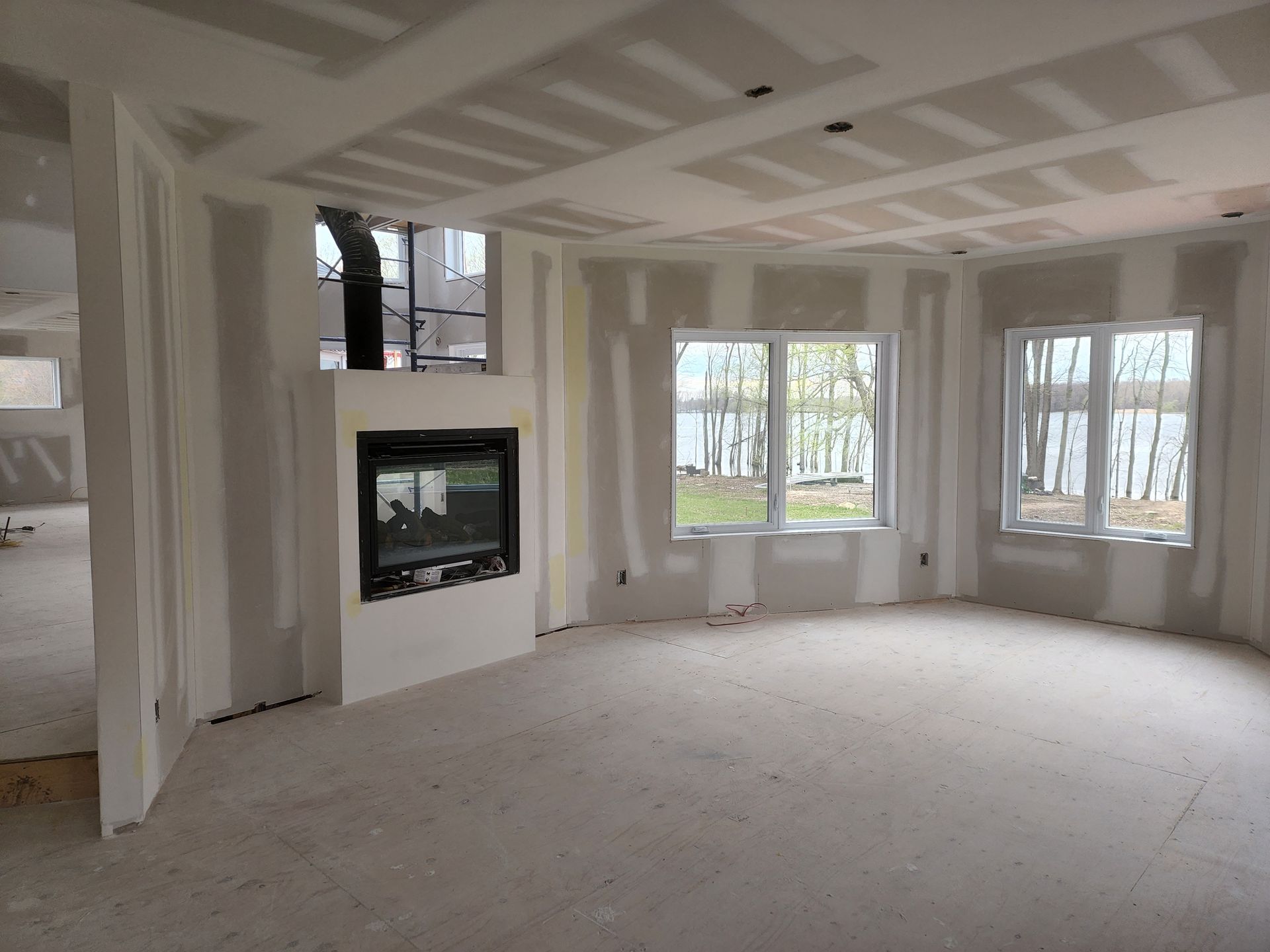 Une pièce vide avec une cheminée et beaucoup de fenêtres