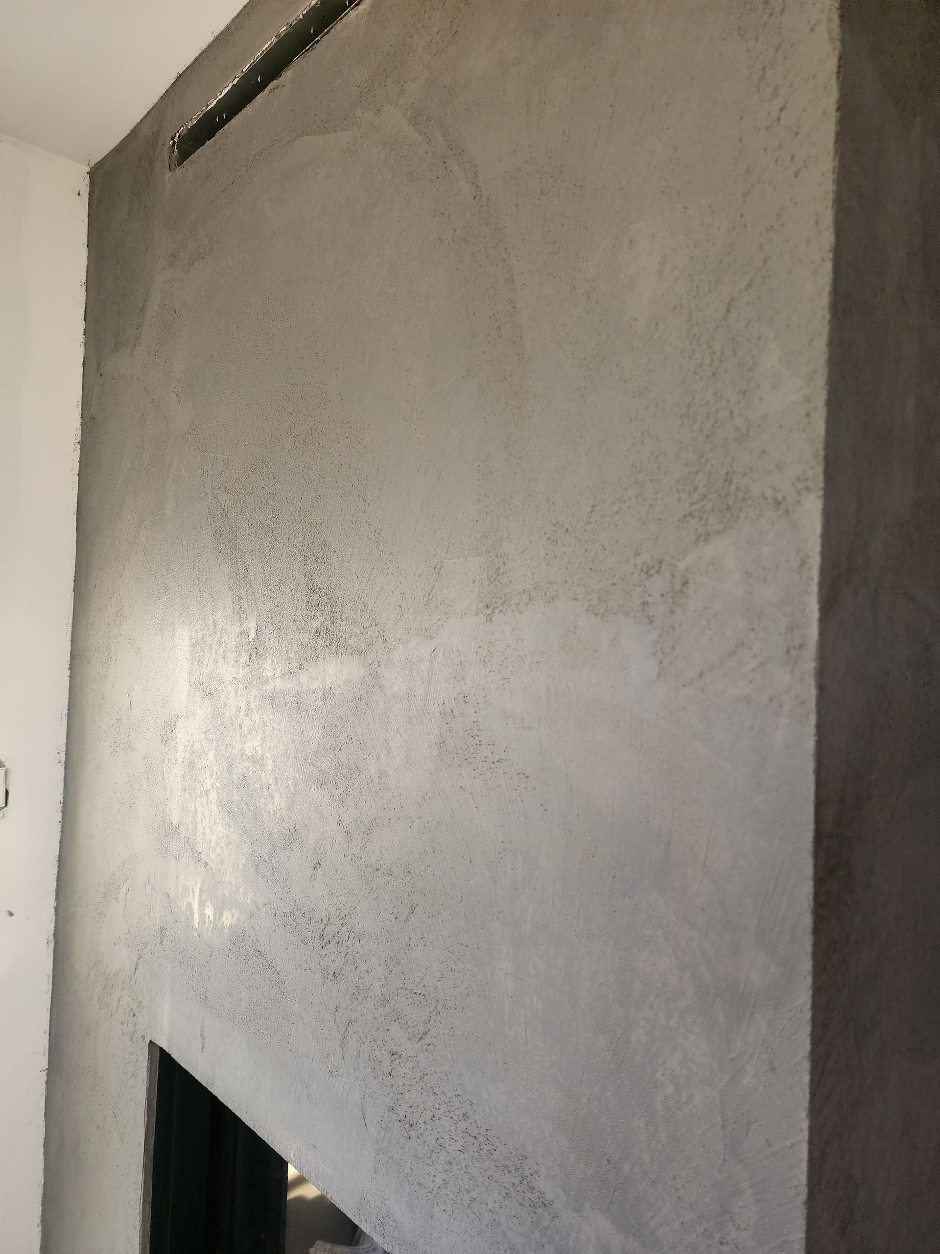 Une cheminée entourée d'un mur en béton dans un salon.