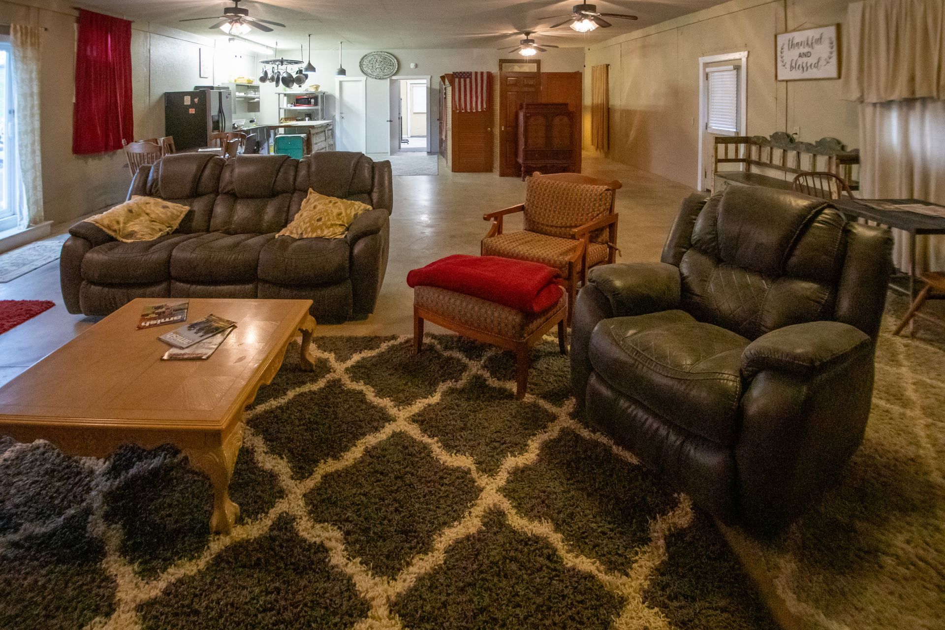 Living room with dark brown leather furniture, patterned rug, and open layout.