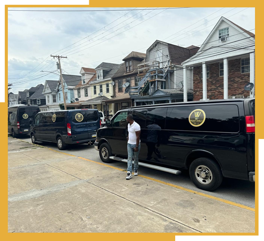 A man is standing in front of a row of vans parked on the side of the road.