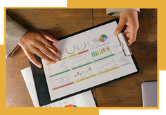 A person is holding a clipboard with a graph on it.
