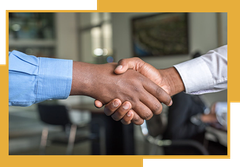 Two men are shaking hands in a room.