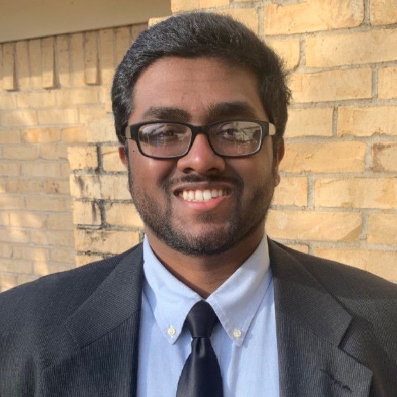 A man in a suit and white shirt is smiling for the camera.