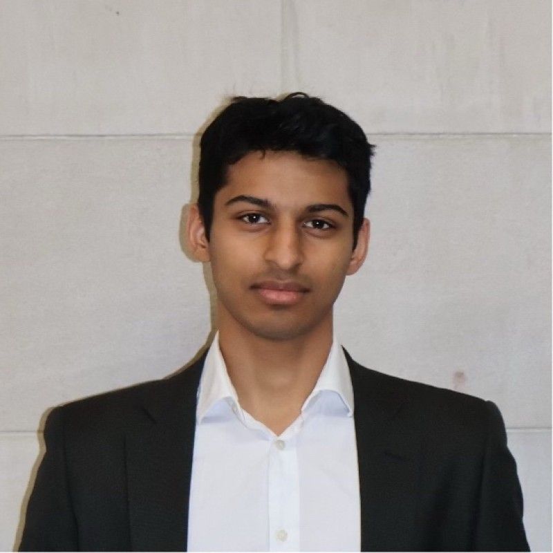 A man in a suit and striped shirt is smiling for the camera.