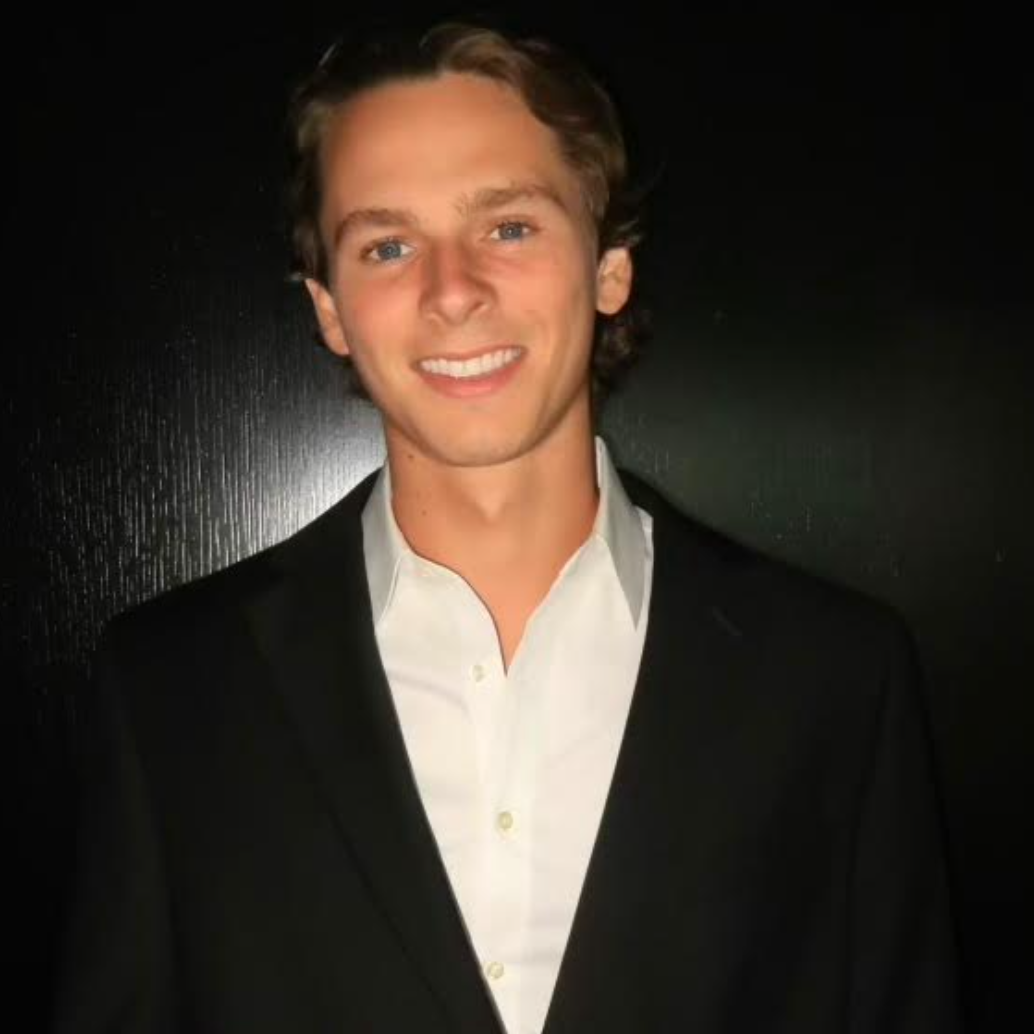 A man in a suit and striped shirt is smiling for the camera.