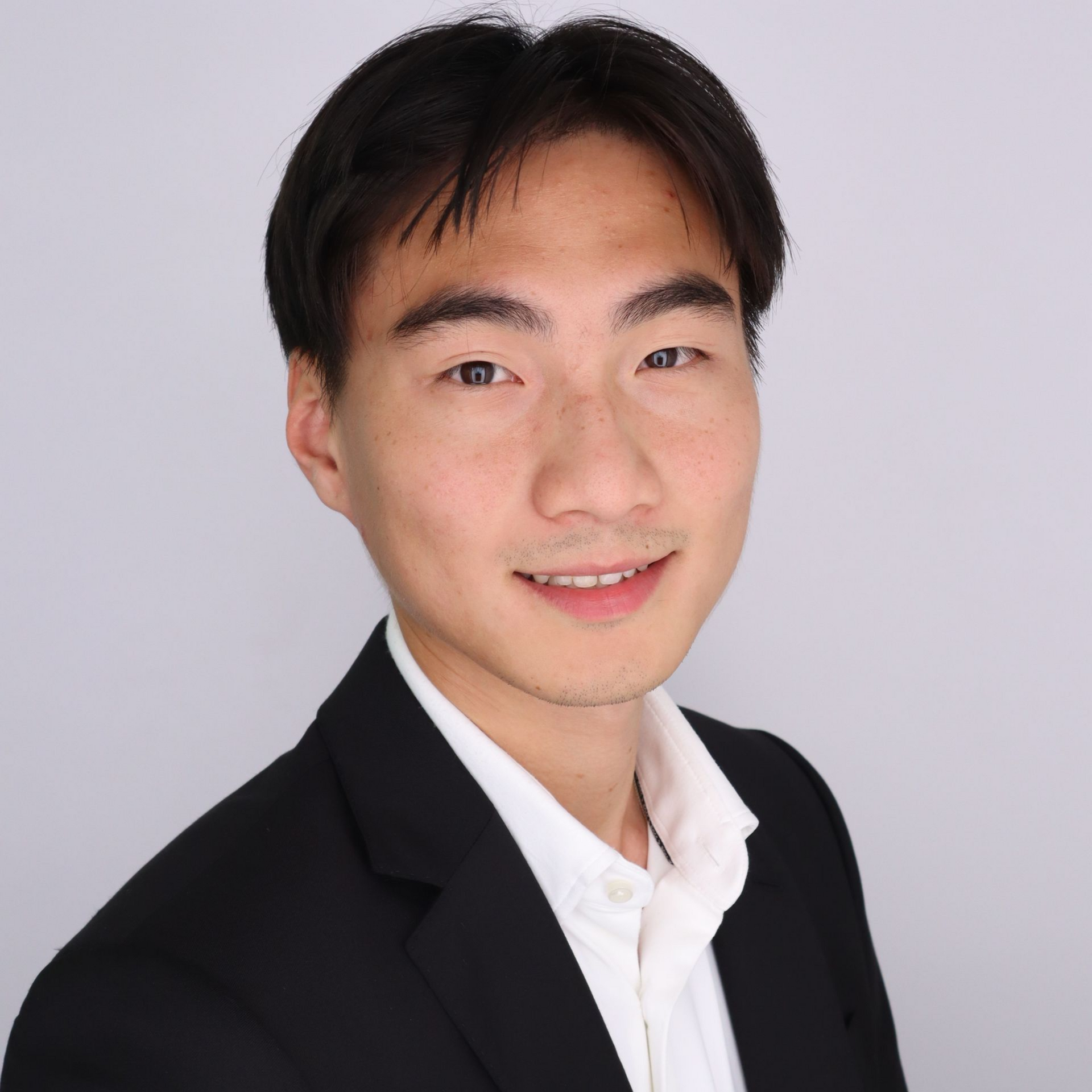 A man in a suit and striped shirt is smiling for the camera.