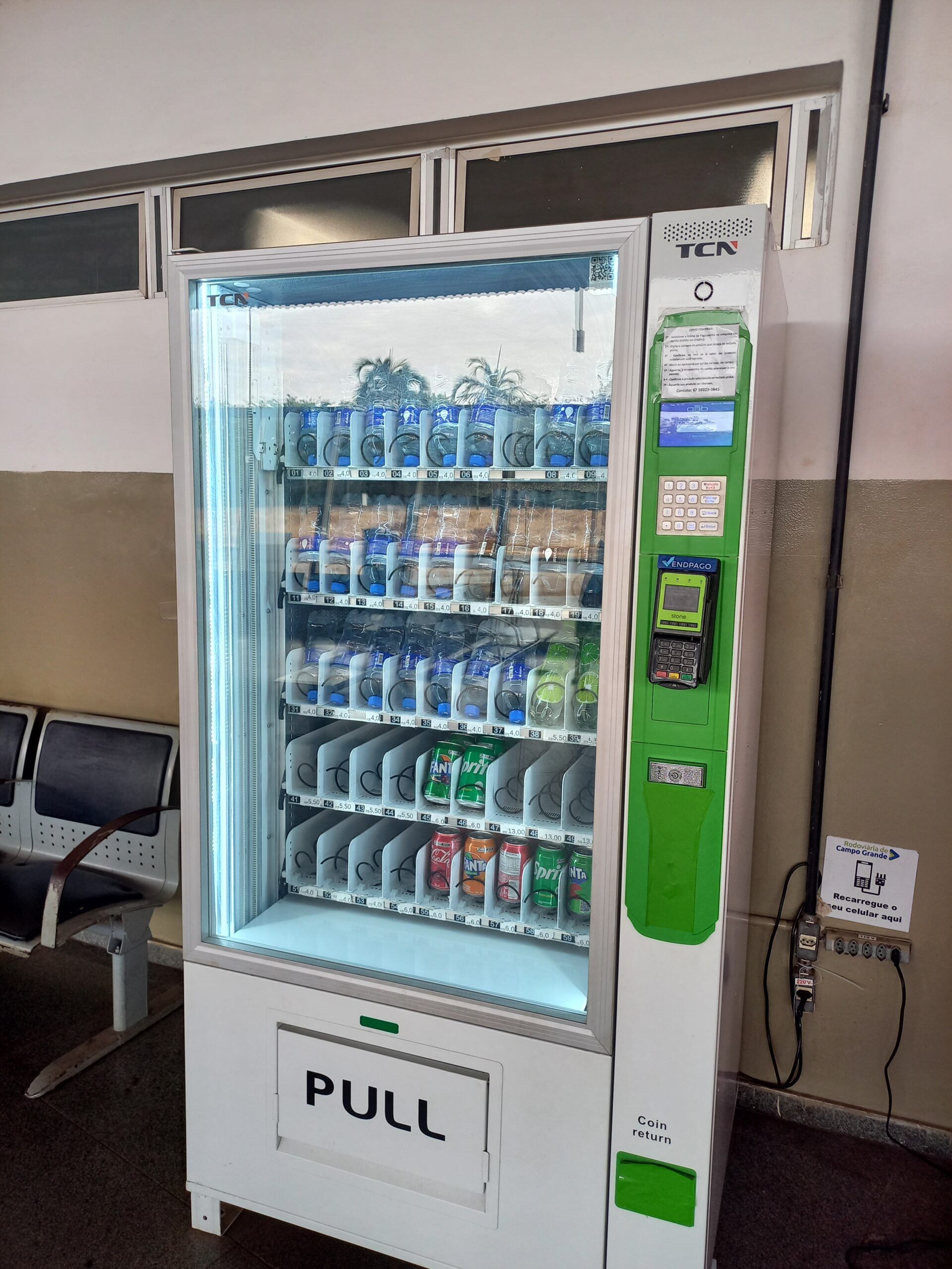 Máquina de venda automática com visor iluminado localizada dentro de um edifício. Etiqueta