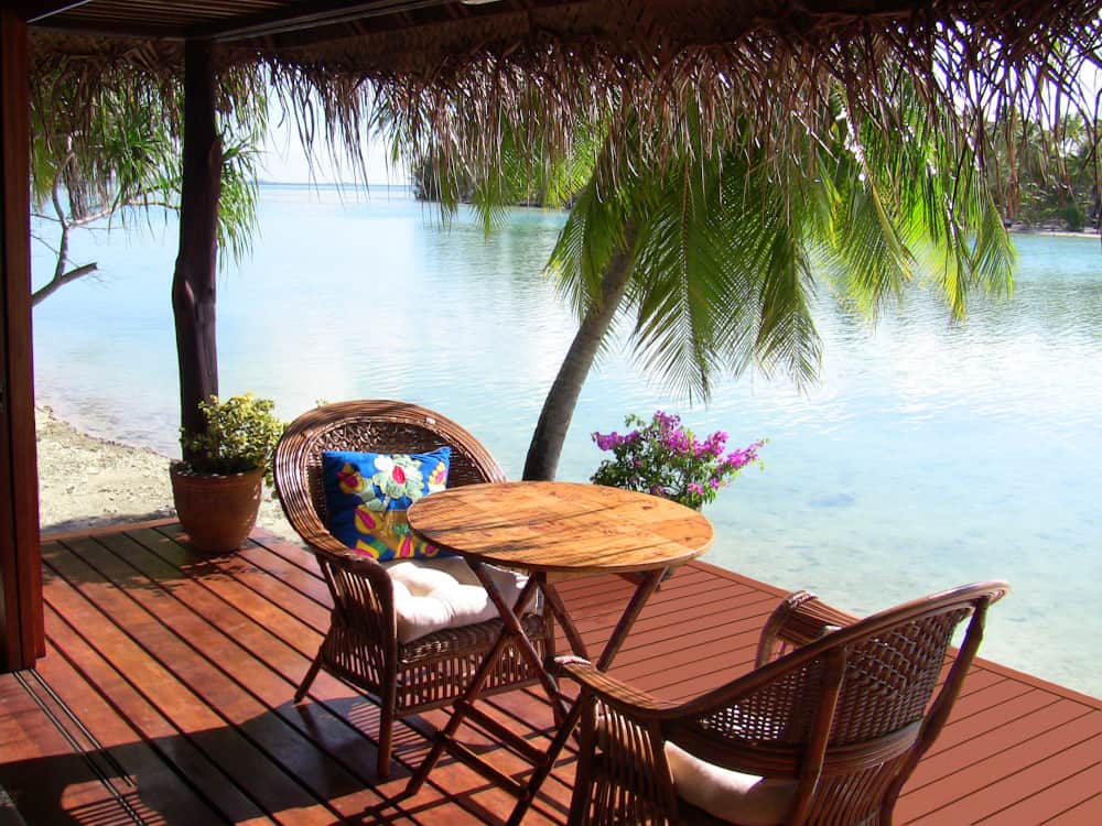 A table and chairs on a deck overlooking the ocean