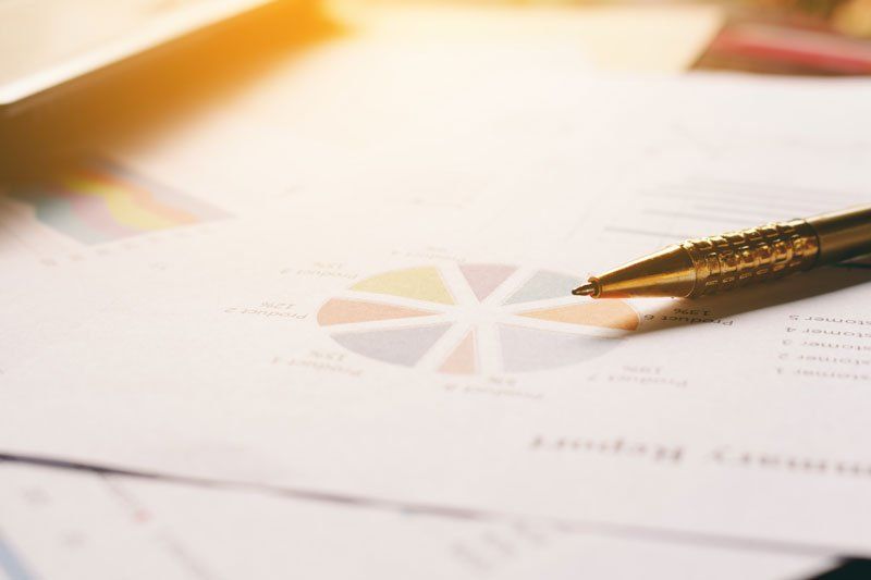 A pen is sitting on top of a piece of paper with a pie chart on it.