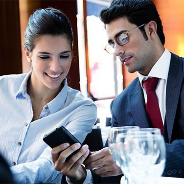 A man and a woman are looking at a cell phone