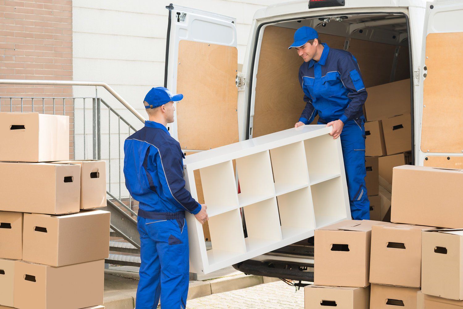 Two men are loading a shelf into a van.