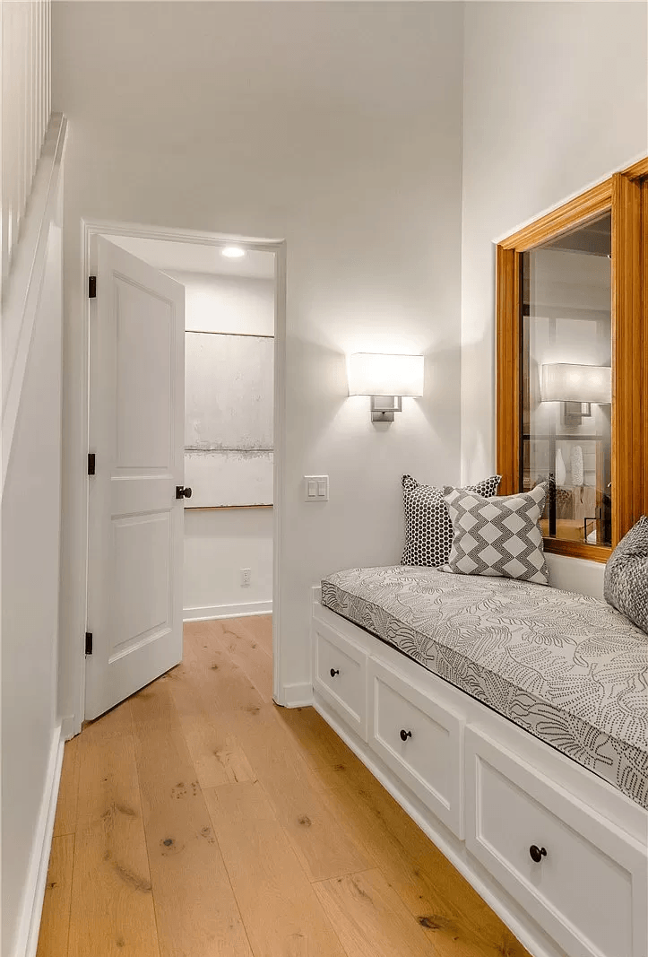 A hallway with a bench and a window.