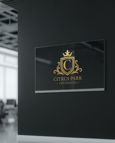 A glass plaque on a black wall featuring the gold-colored Citrus Park Insurance logo with a crown, shield, and letter C.