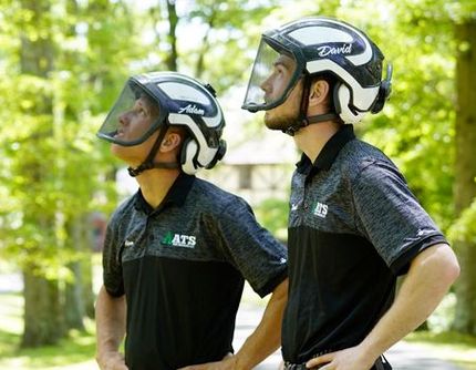 Two men wearing helmets and goggles are standing next to each other.