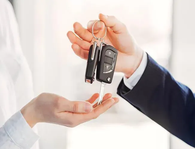 a locksmith is holding a car key in their hand .