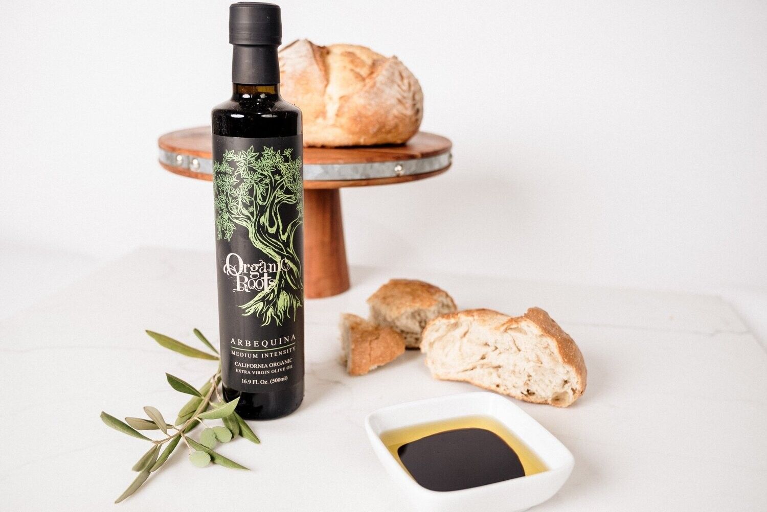 Olive oil pouring from a tap into a glass bottle; hand holding the bottle.