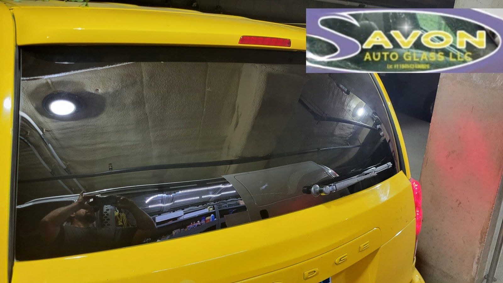 Yellow car with cracked rear window, likely in a garage. 