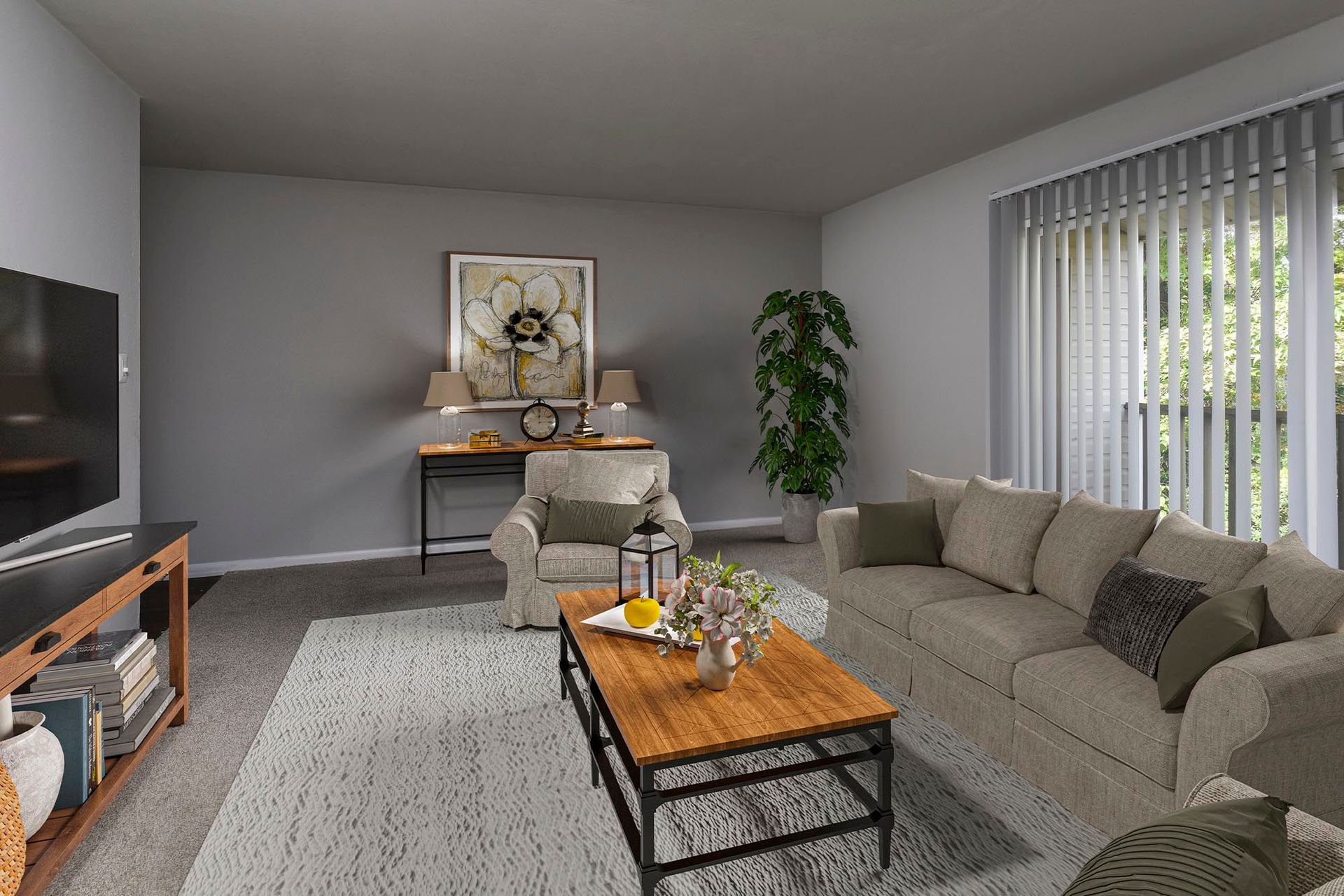 Living room in an apartment with beige sofas, a wooden coffee table, TV, and a large window with vertical blinds at Chesapeake Pointe, offers apartments in Chesapeake, VA.