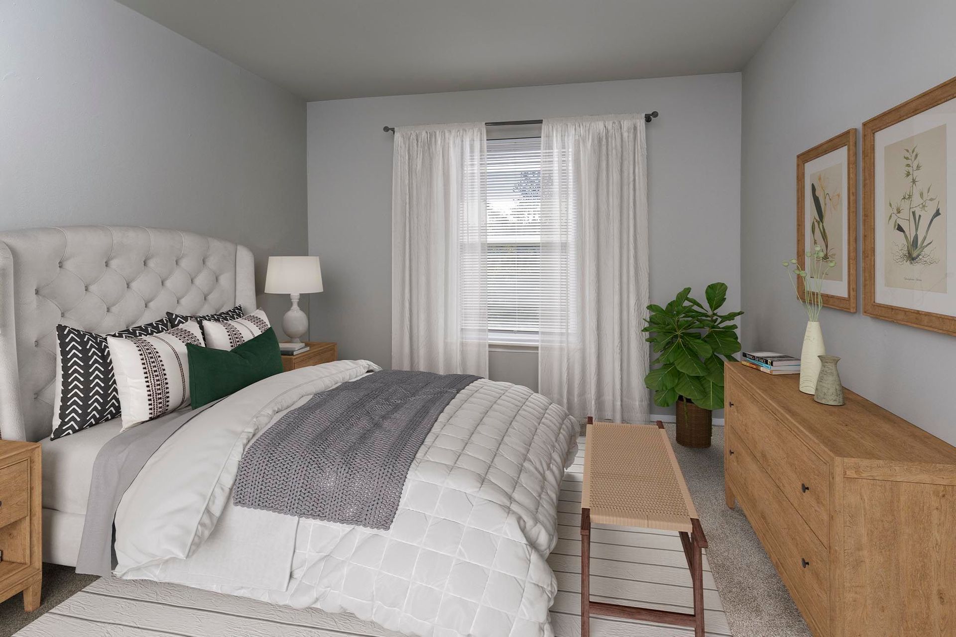 Bedroom with tufted headboard bed, white bedding, wooden dresser, plant, and window with sheer curtains at Chesapeake Pointe, offers apartments in Chesapeake, VA.
