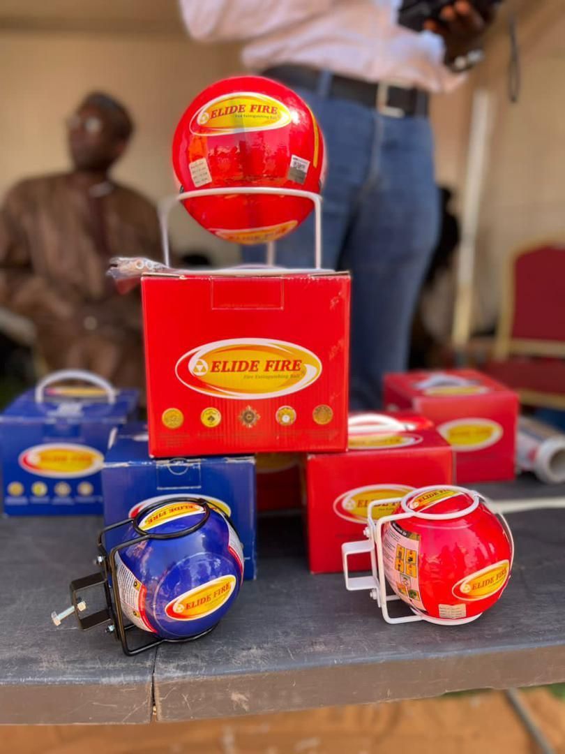 Extincteurs rouges et bleus sur une table, probablement démonstration d'un nouveau produit.