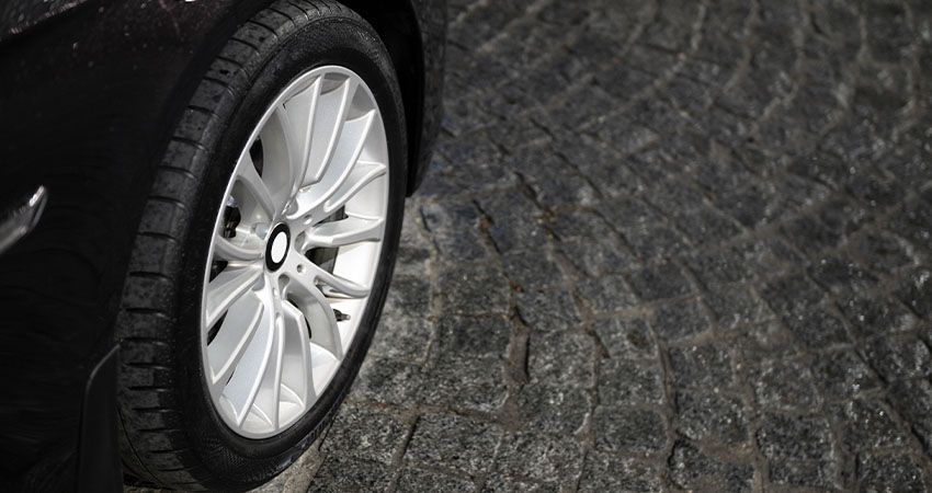 a close up of a car wheel on a cobblestone road .