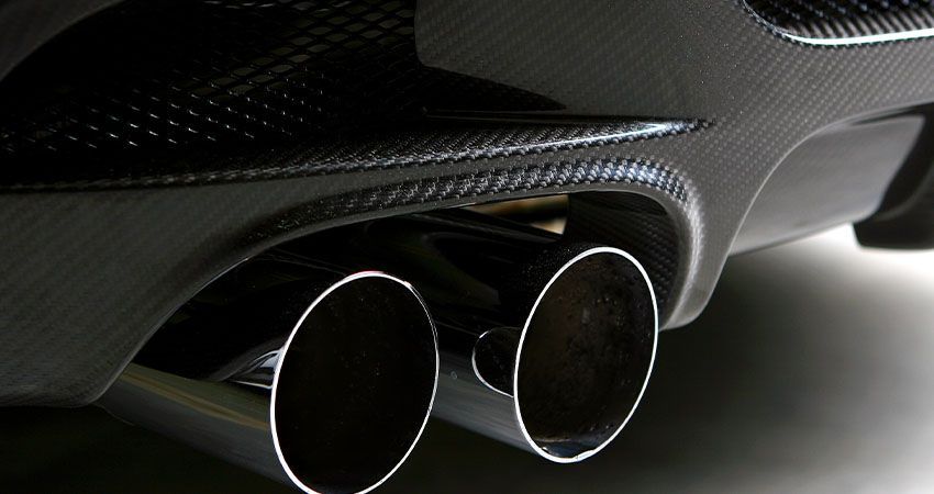 a close up of a car 's exhaust pipes on a white surface .