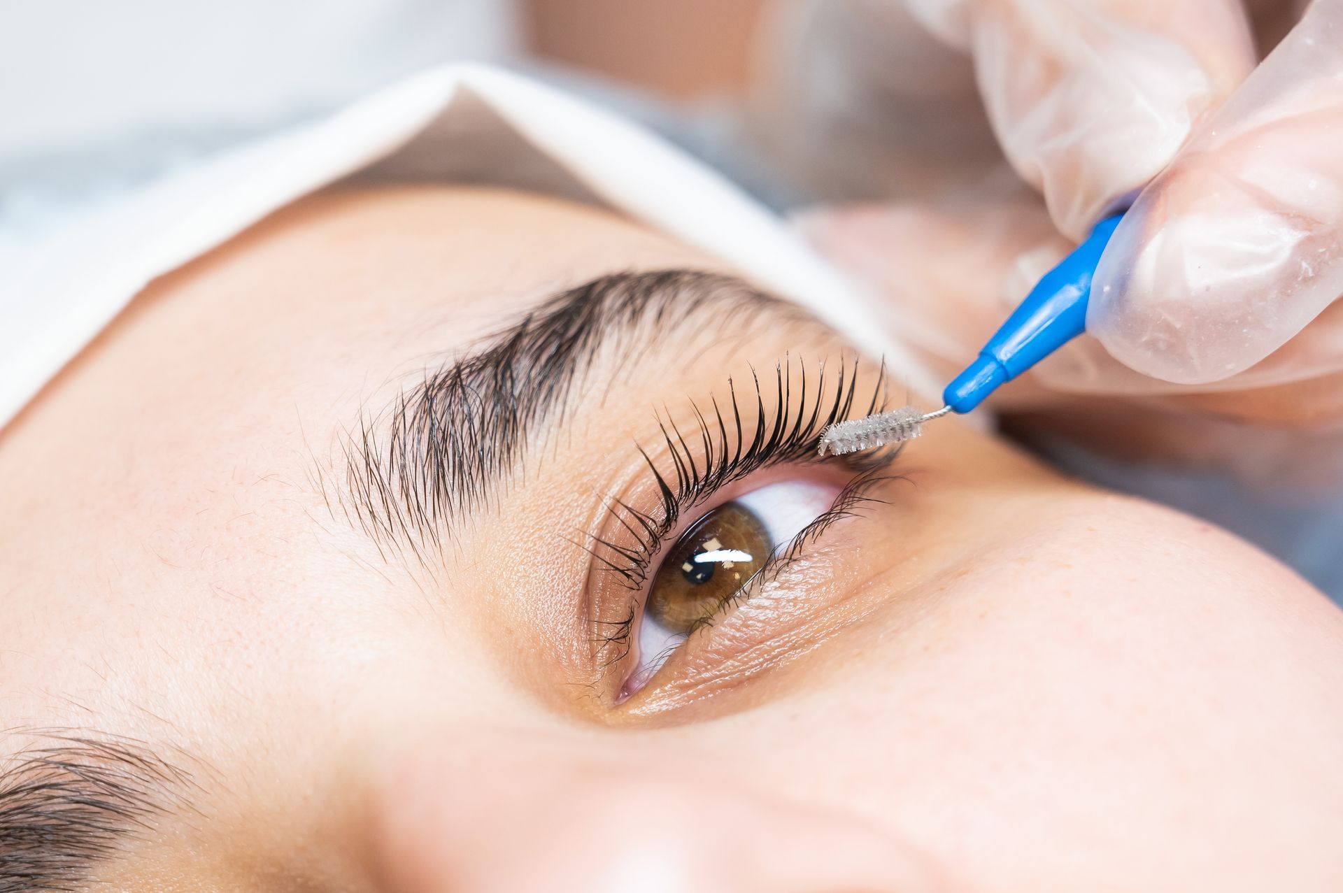 A close up of a woman 's eye being cleaned with a brush.