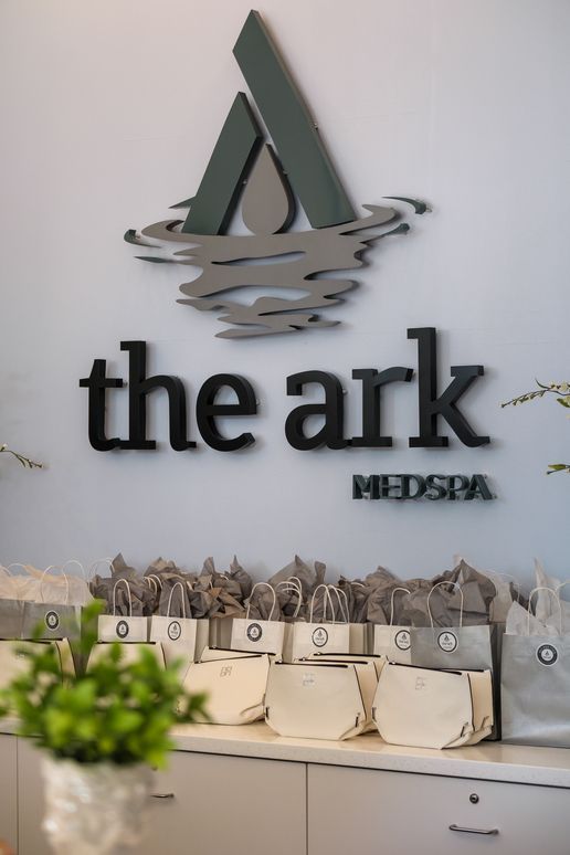 A close up of a woman 's face with a ponytail on a gray background.