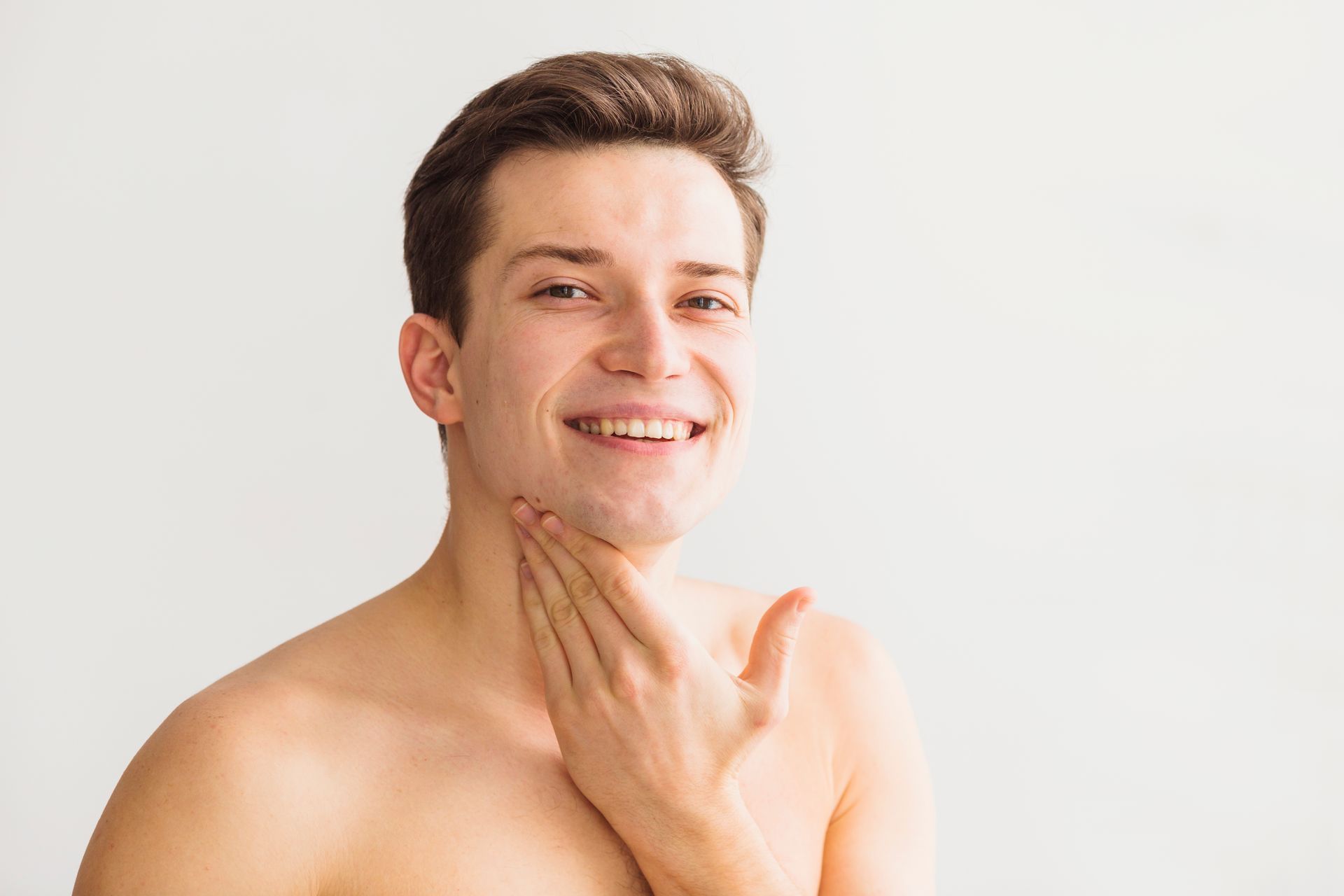 a man smiling and touching his face