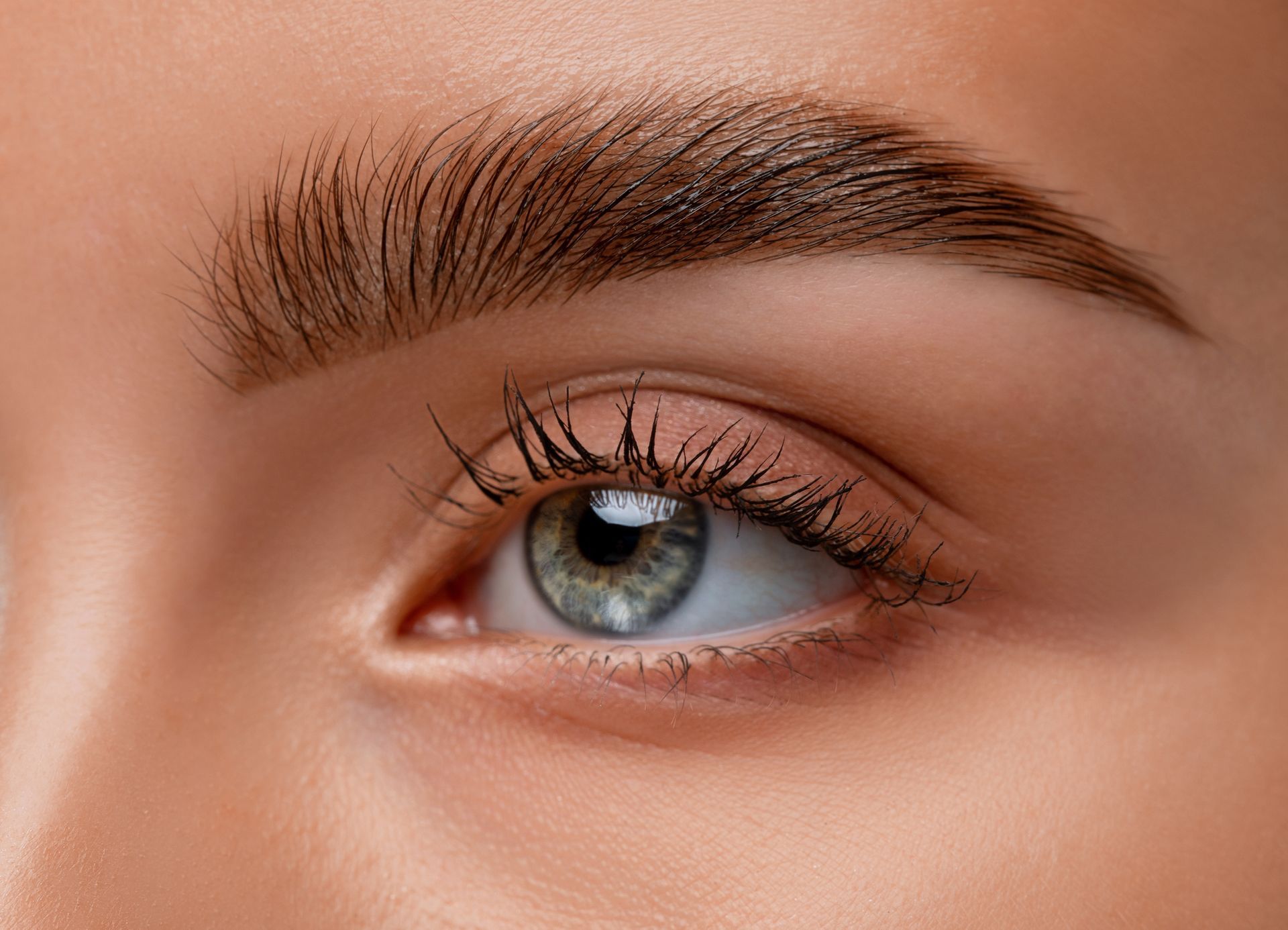 A close up of a woman 's eye with long eyelashes.